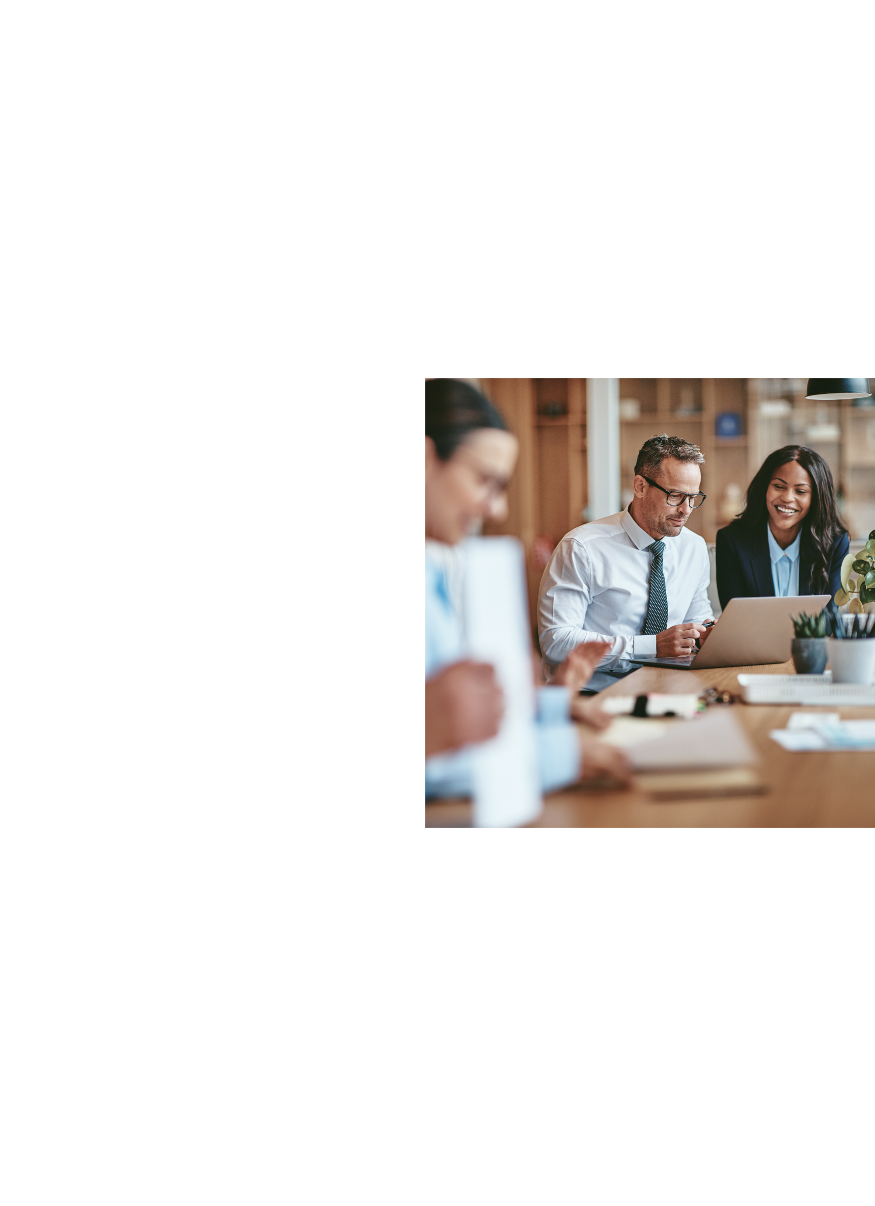Colleagues at a law firm look at a laptop together. 